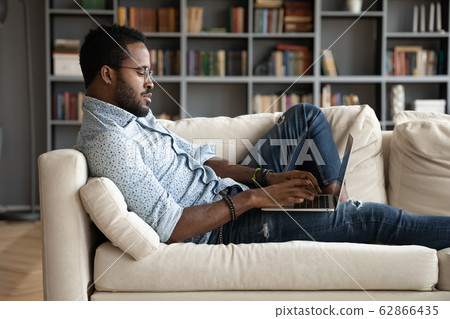 Concentrated mixed race young businessman communicating with partners clients. 62866435