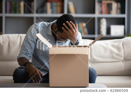 Stressed young multiracial man, feeling desperate about ordering wrong item. Stressed young multiracial man, feeling desperate about ordering wrong item. 62866509