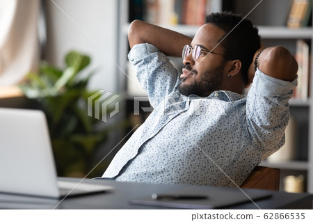 Peaceful carefree young african american guy relaxing on comfortable chair. Peaceful carefree young african american guy relaxing on comfortable chair. 62866535