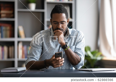 Focused millennial businessman checking email in mobile application. 62866566