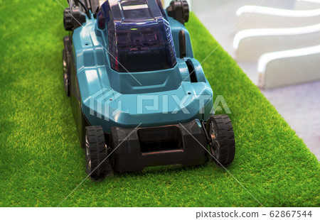 Turquoise lawn mower on grass 62867544