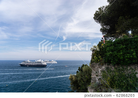Two cruise ships at sea during sunny day surrounded by lots of powerboats. Monte Carlo, Monaco. 62868203