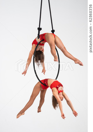 Twins female circus duo on the Aerial hoop isolated on white Twins female circus duo on the Aerial hoop isolated on white 62868356