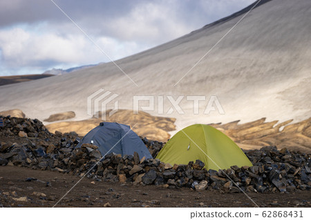 Camping with tents. Snowy mountain glaciers and storm wind. Iceland. Camping with tents. Snowy mountain glaciers and storm wind. Iceland. 62868431