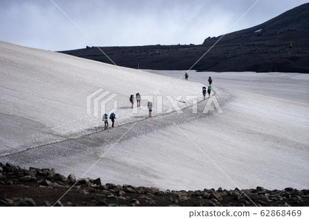 Landscape View Glacier With Group Of Hikers with backpack Walking On Glacier. Iceland Landscape View Glacier With Group Of Hikers with backpack Walking On Glacier. Iceland 62868469