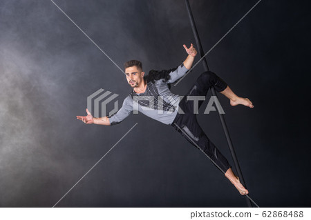 Performance concept. Man hanging on chinese pole. Athlete performing flying pole 62868488