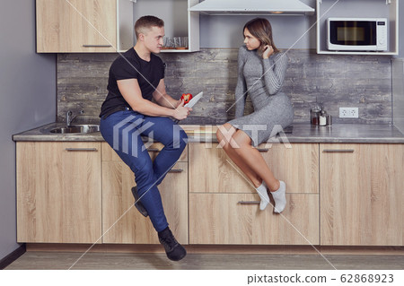 Student flirts with a young woman in dorm kitchen. 62868923