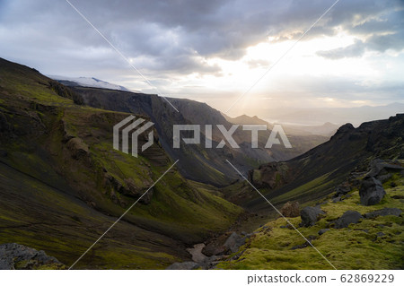 Canyon and Mountain peak during dramatic and colorful sunset on the Fimmvorduhals Hiking trail near Canyon and Mountain peak during dramatic and colorful sunset on the Fimmvorduhals Hiking trail near 62869229