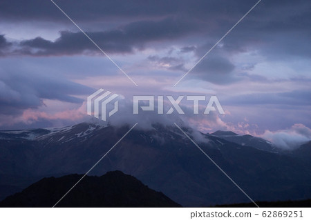 Mountain peak with snow and clouds during dramatic and colorful sunset on the laugavegur Hiking Mountain peak with snow and clouds during dramatic and colorful sunset on the laugavegur Hiking 62869251