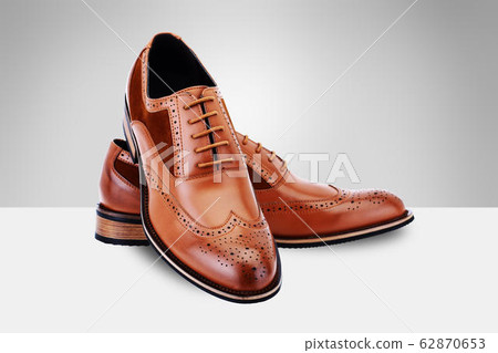 A pair of brown men's shoes on split background A pair of brown men's shoes on split background 62870653