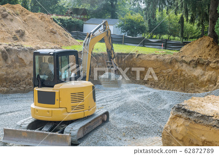 Excavator digging bucket scooping gravel from a 62872789