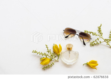 bottle perfume ,sunglasses and yellow flower ylang ylang of lifestyle woman 62876638