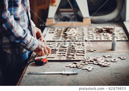 The carpenter works with a tree 62879953