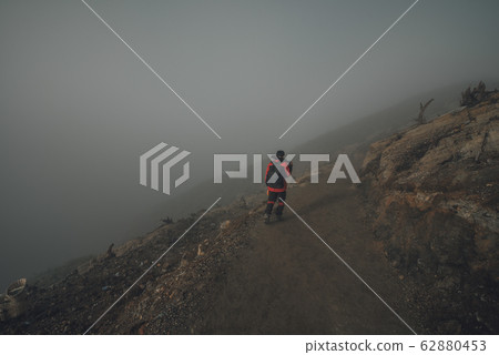 A guide of Kawah Ijen walking alone on the crater A guide of Kawah Ijen walking alone on the crater 62880453