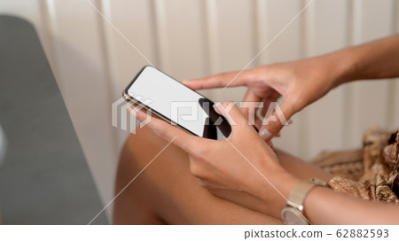 Side view of female using smartphone on her lap 62882593