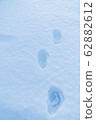 Man's footsteps on the snow in the winter 62882612