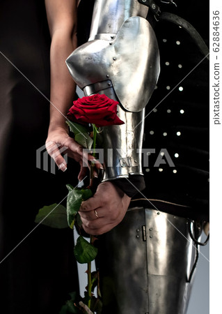 Knight and woman hold a rose in hands Knight and woman hold a rose in hands 62884636