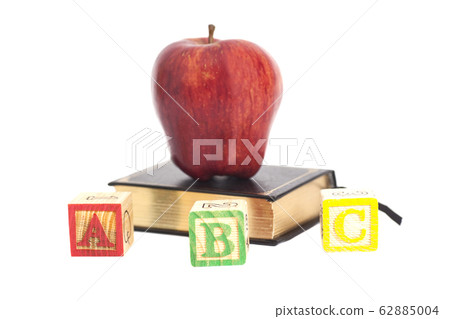 Red apple on book and ABC wooden letter blocks 62885004