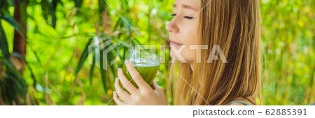 Young woman drinks Celery Juice, Healthy Drink, bunch of celery on a wooden background BANNER, LONG 62885391