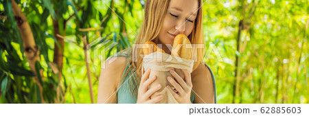 Reusable grocery bags with bread in the hands of a young woman. Zero waste shopping. Zero waste Reusable grocery bags with bread in the hands of a young woman. Zero waste shopping. Zero waste 62885603