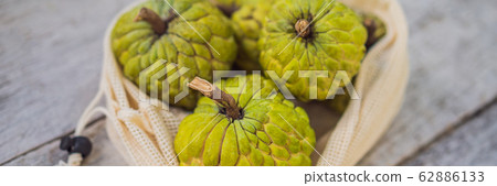 Cherimoya in a reusable bag on a stylish wooden kitchen surface. Zero waste concept, plastic free 62886133