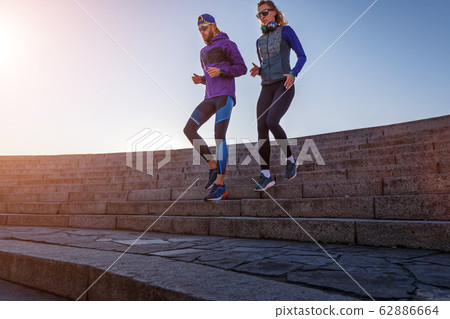 Sporty couple running down on the stairs 62886664