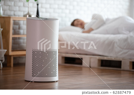 woman sleep with Air purifier in cozy white bed room for filter and cleaning removing dust PM2.5 62887479