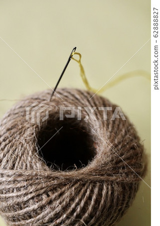 麻繩上的繡花針和黃色繡線 62888827