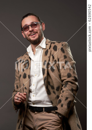 Happy male in sunglasses in jacket on brown background 62890542