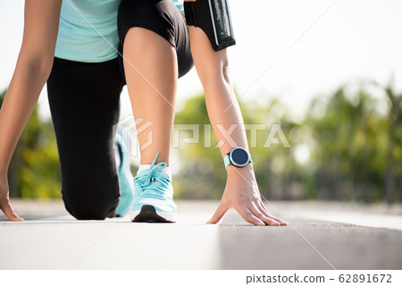 Front view of athletic women in running start pose 62891672
