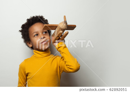 Playful clever black child boy with plane model 62892051