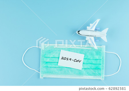Protective face mask and airplane model on blue 62892381