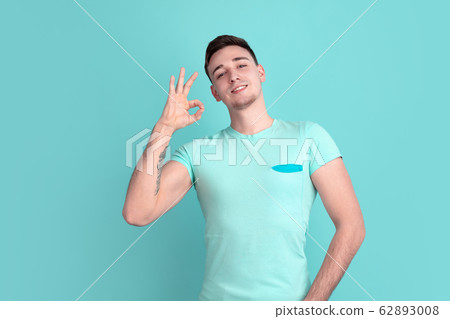 Caucasian young man's portrait on blue studio background 62893008
