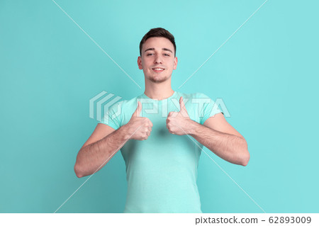 Caucasian young man's portrait on blue studio background Caucasian young man's portrait on blue studio background 62893009