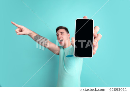 Caucasian young man's portrait on blue studio background 62893011