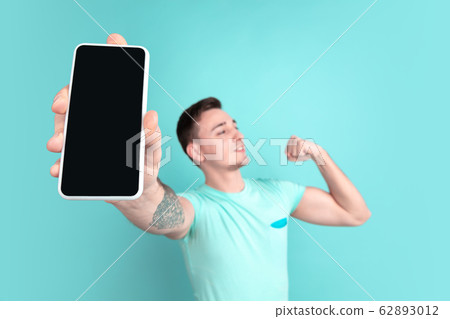 Caucasian young man's portrait on blue studio background Caucasian young man's portrait on blue studio background 62893012