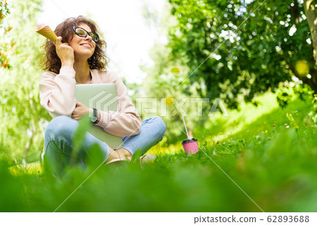Pretty young caucasian woman go for a walk at park with coffe and earphones Pretty young caucasian woman go for a walk at park with coffe and earphones 62893688