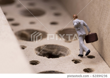 Businessman running while avoiding many pitfalls Businessman running while avoiding many pitfalls 62894236
