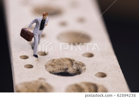 Businessman running while avoiding many pitfalls Businessman running while avoiding many pitfalls 62894238