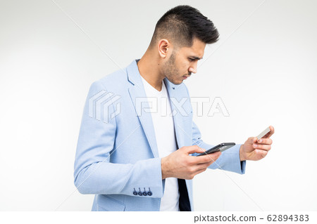 a man enters data with a credit card into a mobile phone to make a purchase via the Internet on a 62894383