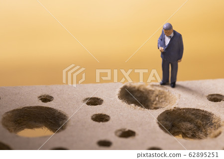 Businessman looking at pitfalls at his feet 62895251