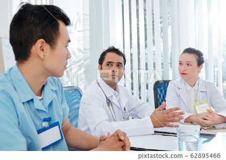 Doctors listening to surgeon Doctors listening to surgeon 62895466