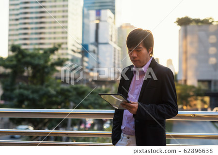Businessman work on tablet outside office at 62896638
