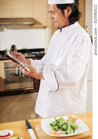 Chef reading recipe on tablet screen 62896922