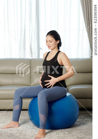 Pregnant woman sitting on fitness ball Pregnant woman sitting on fitness ball 62896994