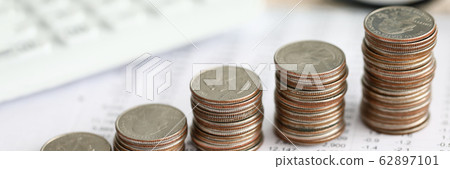 Row of silver coins standing at financial report paper Row of silver coins standing at financial report paper 62897101