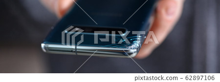 Man hold in hand modern smartphone with cracked corner 62897106