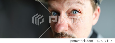 Suspicious male worker trying to see something 62897107
