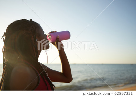 Female jogger drinking fresh water 62897331