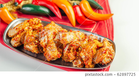 Raw and fresh chicken wings in a siriracha Raw and fresh chicken wings in a siriracha 62897725